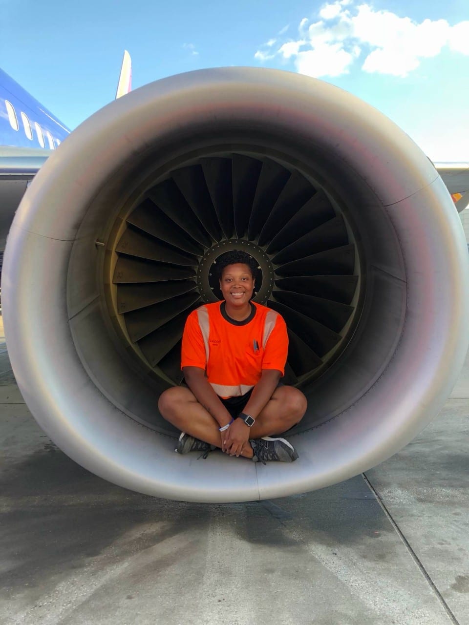 Jalonni Weaver in aviation gear inside a jet engine | intrapreneurship and personal branding in corporate life